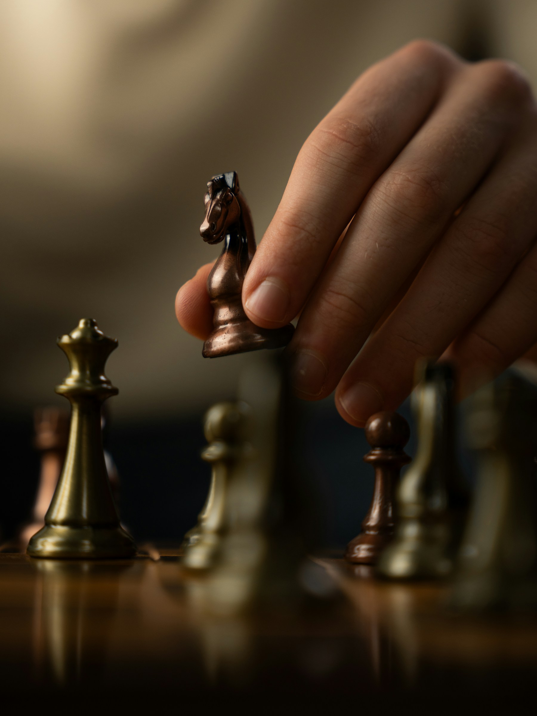 Hand moving a chess knight piece during a game.