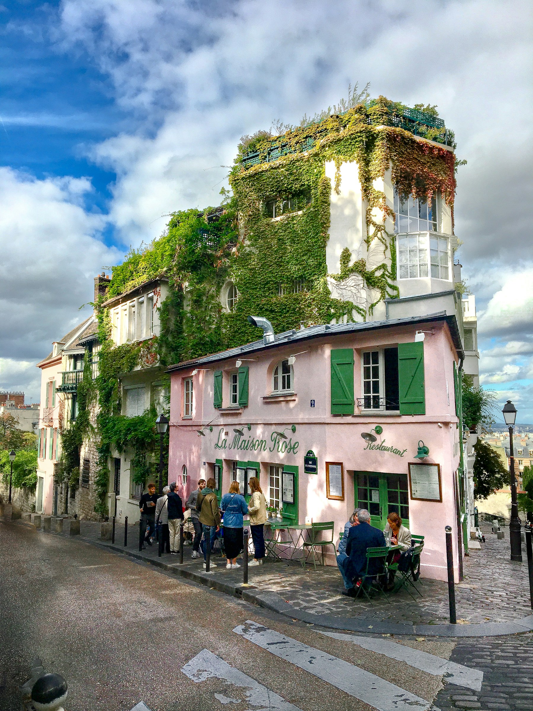 A group of people standing outside of a pink building